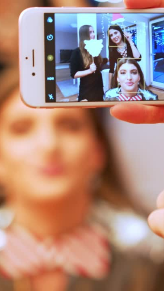 Women taking a picture with their cellphone because they didn't choose a photo booth